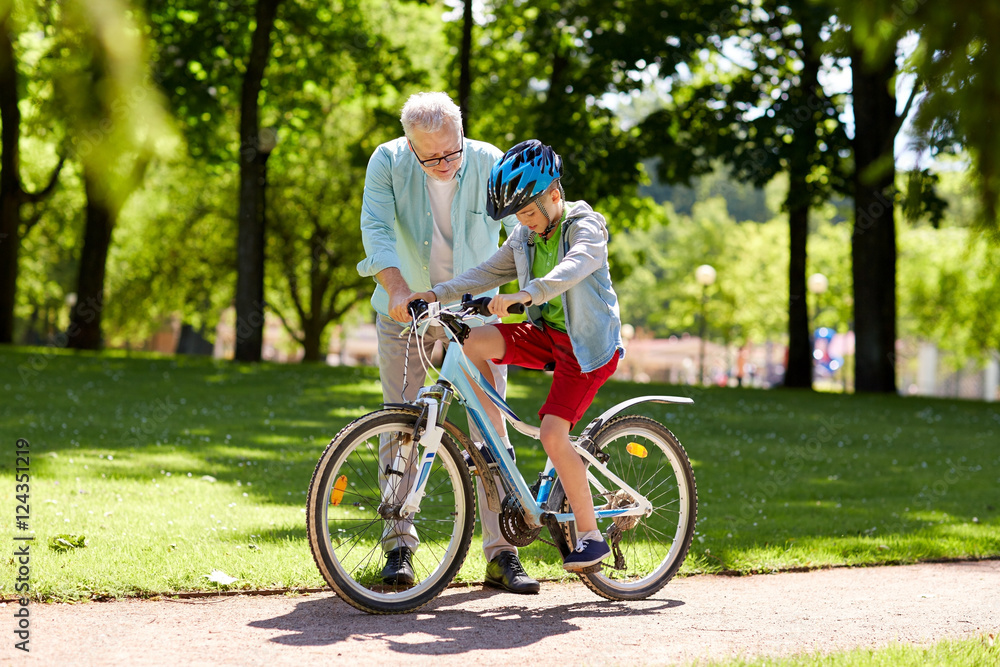 Fototapeta premium grandfather and boy with bicycle at summer park
