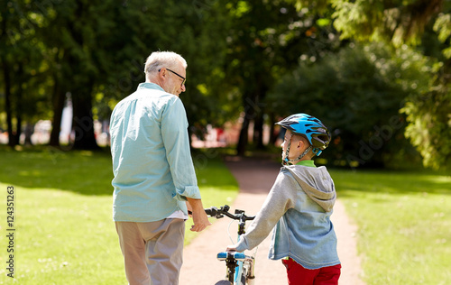 grandfather and boy with bicycle at summer park