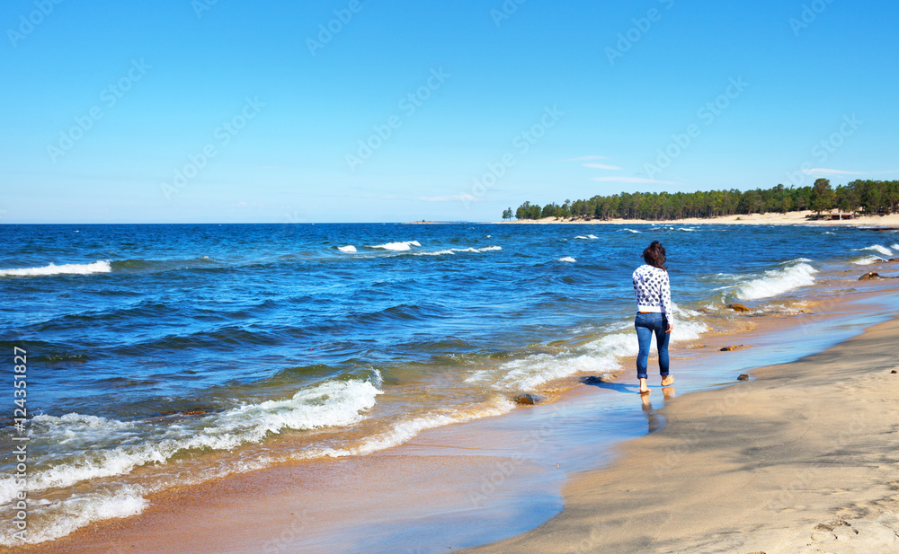 She goes barefoot on the sandy shores of Lake Baikal 