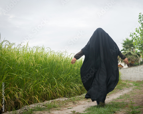Bild auf Leinwand Beautiful happy Muslim woman in green field