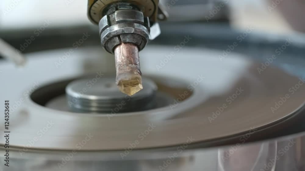 Closeup of diamond held by dop and polishing it on faceting machine Closeup of diamond held by dop and polishing it on faceting machine