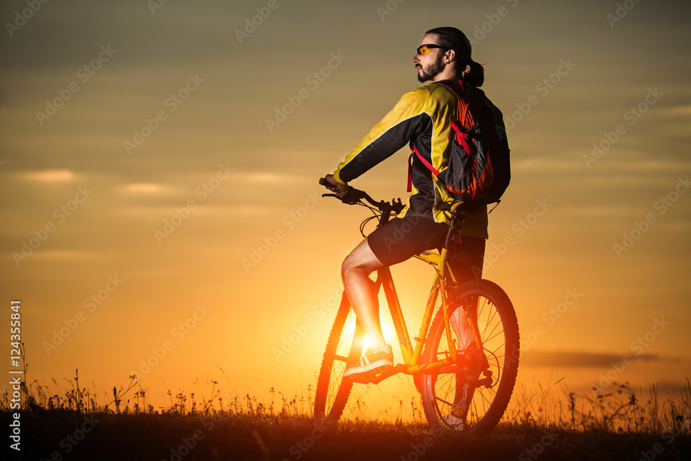 silhouette of the cyclist riding a road bike at sunset silhouette of the cyclist riding a road bike at sunset