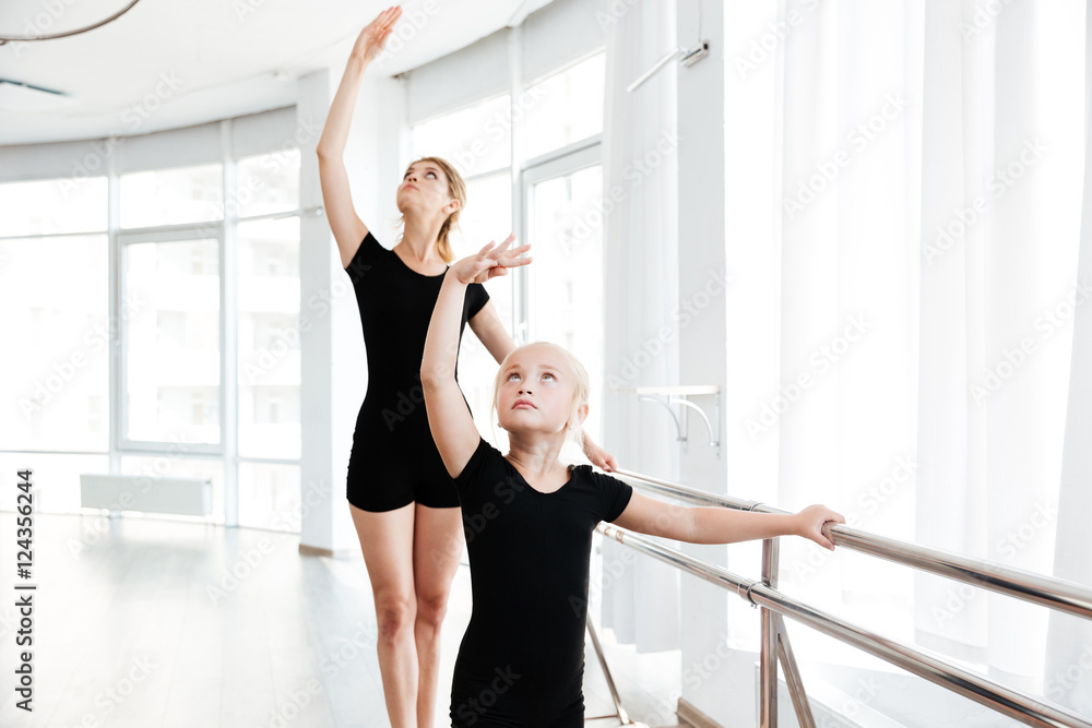 Little ballerina and teacher dancing tiptoes in dance studio Little ballerina and teacher dancing tiptoes in dance studio