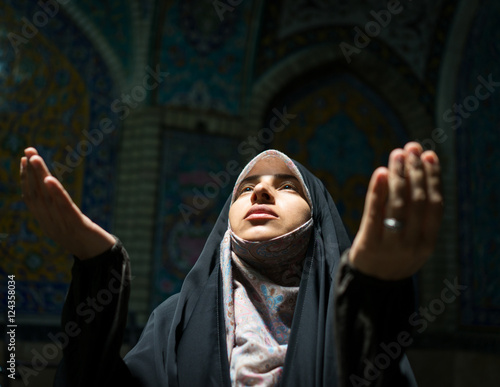 Bild auf Leinwand Beautiful Muslim woman praying inside dark mosque