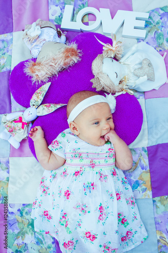Cute little girl on the violet coverlet