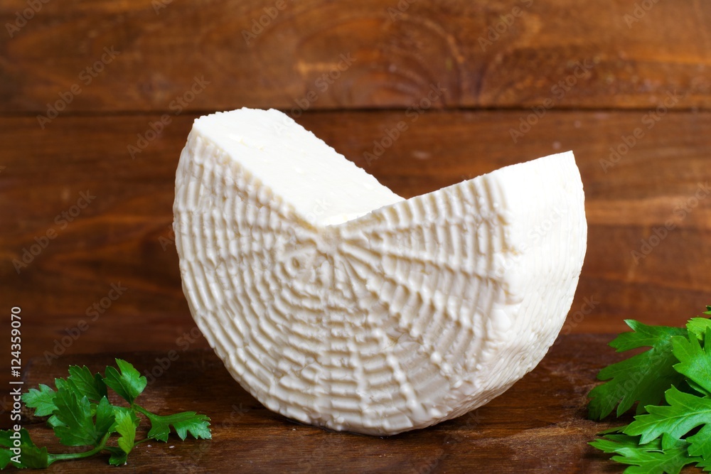 Obraz premium Soft salty cheese on a wooden table
