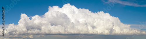 Blue sky with big fluffy cumulus cloud wide panoramic background
