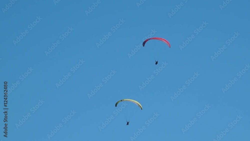 Unrecognizable paragliders enjoying up in sky, people paragliding as a way of recreational and competitive adventure sport activity. Unrecognizable paragliders enjoying up in sky, people paragliding as a way of recreational and competitive adventure sport activity.