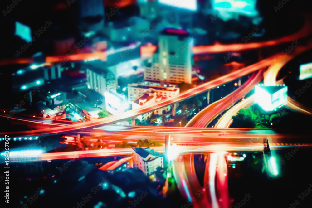 Obraz premium Blurred abstract futuristic night cityscape aerial view panorama with illuminated skyscrapers and city traffic across streets. Bangkok, Thailand