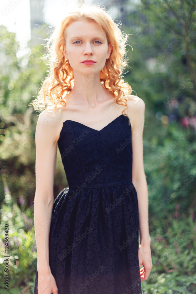 Ginger girl in long black dress on street .tinted photo Ginger girl in long black dress on street .tinted photo