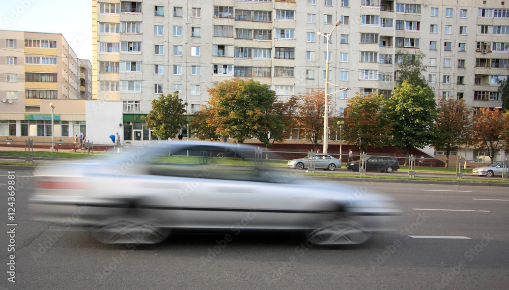 Moving gray  car with motion blur effect / Movement of a blurry gray car down the street in the daytime 