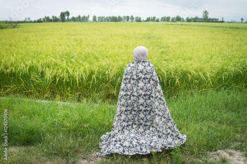 Bild auf Leinwand Beautiful happy Muslim woman in green field