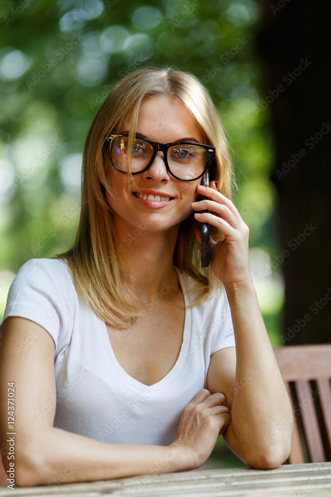 Smiling girl in summer terrace talking on phone Smiling girl in summer terrace talking on phone