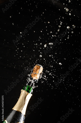 Closeup of champagne explosion. Vertical image on black background © Sergey