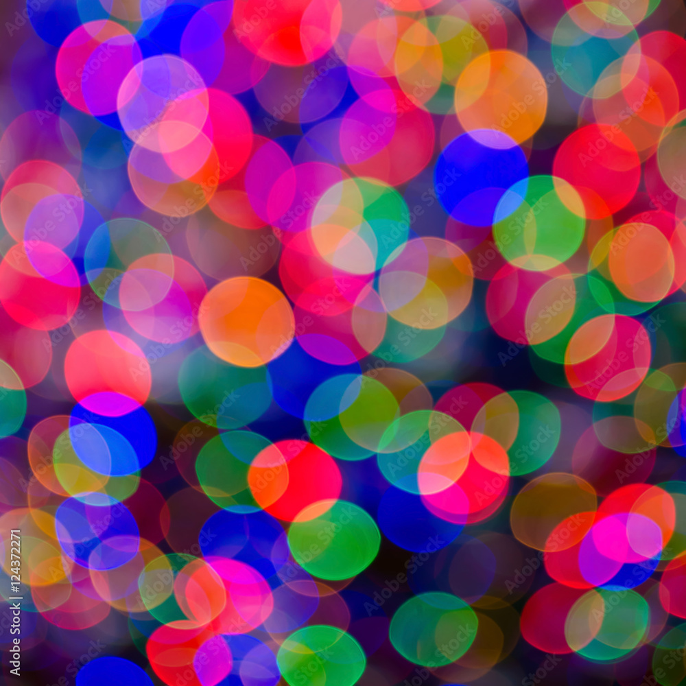 Blurred lights of Christmas light bulbs. There are red, pink, green blue and purple, orange, and yellow colors in the image. Suitable for being used as background. 