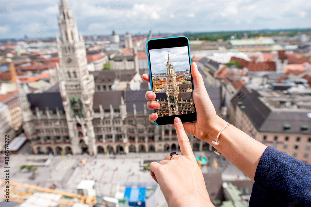 Naklejka premium Photographing with smart phone the clock tower of the town hall in Munich city, Germany