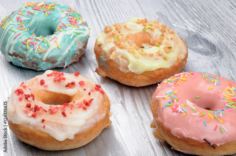 Fresh tasty donuts in soft colorful glaze on a silver wooden background Fresh tasty donuts in soft colorful glaze on a silver wooden background