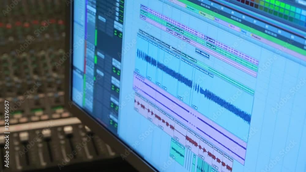 Close up a digital audio workstation with multiple tracks in a music studio. Close up a digital audio workstation with multiple tracks in a music studio.
