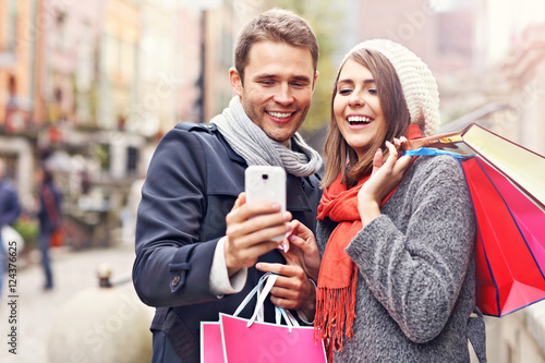 Couple shopping in the city with smartphone