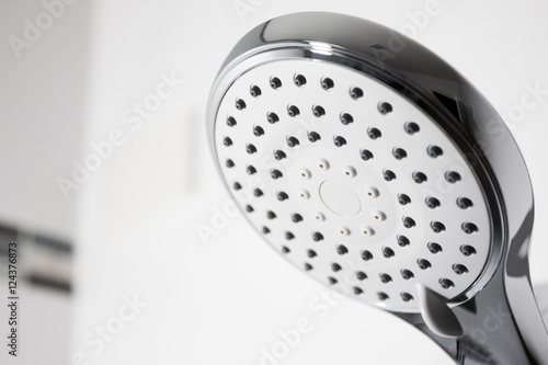 Image of a modern shower head splashing water close up background.