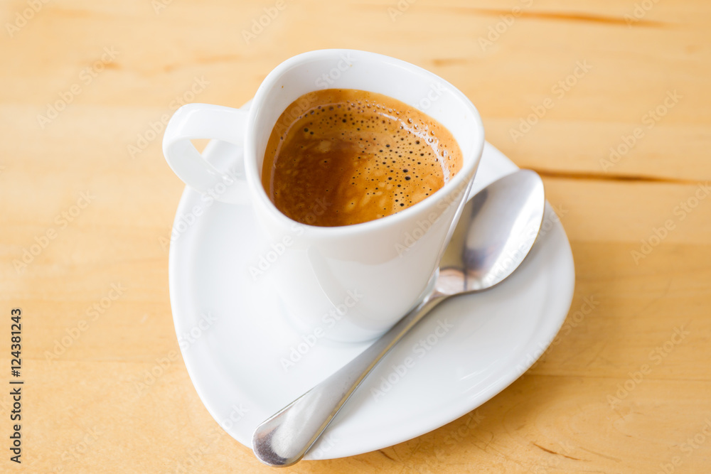 Obraz premium Hot espresso in white cup on wooden table close up.