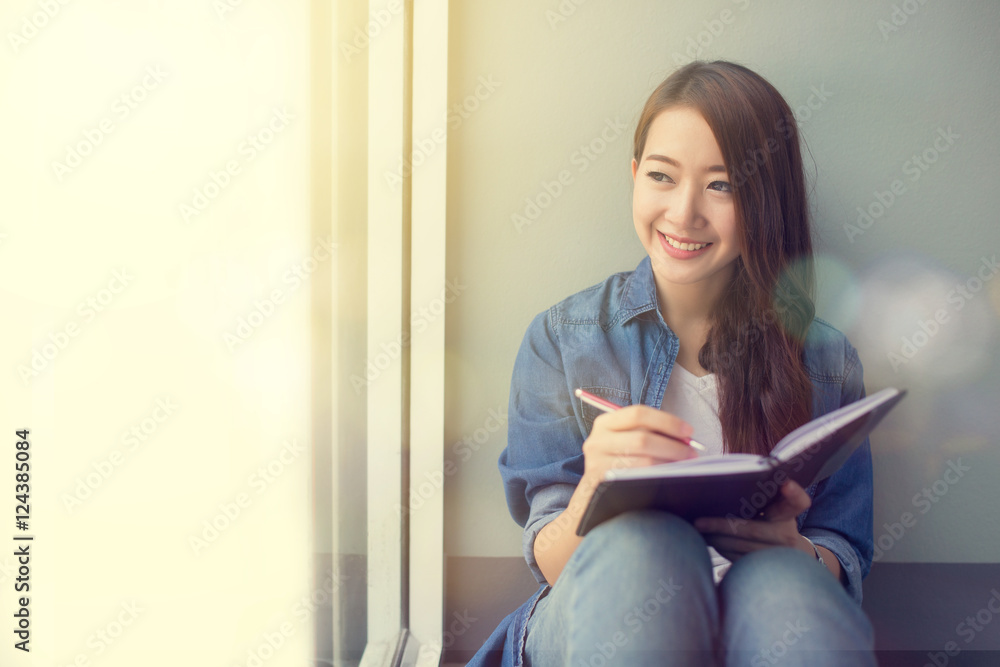 Smiling Asia woman writing on note pad Smiling Asia woman writing on note pad