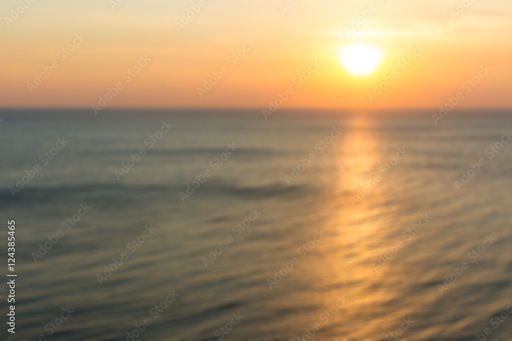 Blur image of ocean in sunset background.