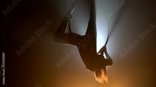 Aerial acrobat woman on circus stage. Silhouette