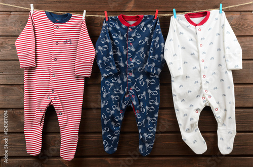 Baby boy clothes (sleepsuits) hanging on the clothesline photo