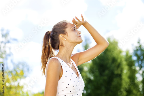 Portrait of beautiful brunette woman looking far, holding her ar