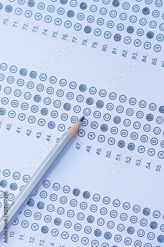 Standardized test form with answers bubbled in and a pencil photo