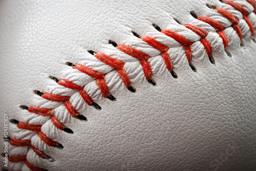 Macro image of a baseball with the closeup on the stitches