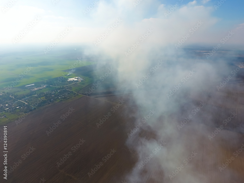 The smoke over the village. Clubs of smoke over the village houses and fields. Aerophotographing areas