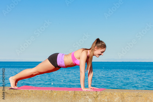 Young woman exercising outside © Voyagerix