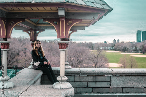Girl sitting on edge of Belvedere Castle at Central Park in Manh photo