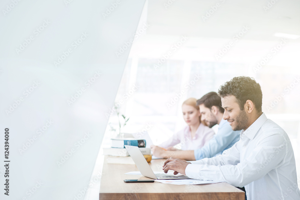 Fototapeta premium Skillful three workers are using a computer