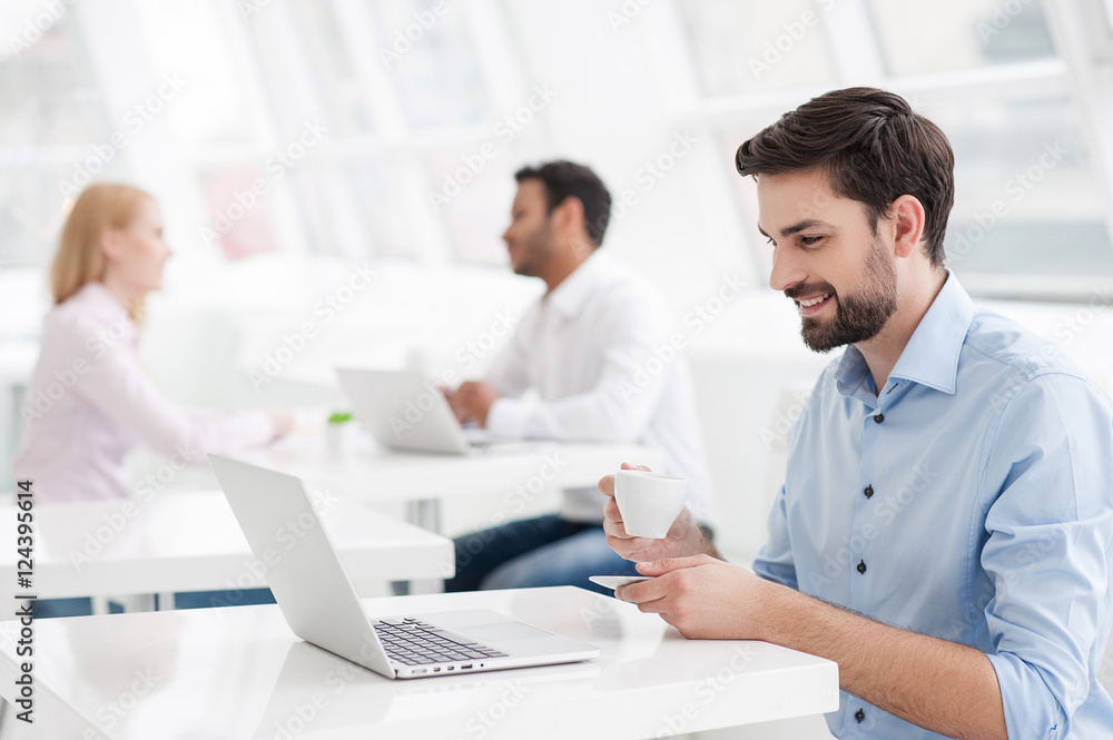 Businessman drinking coffee while working