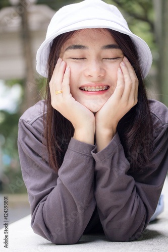 thai adult girl white cap gray T-shirt beautiful girl relax and smile