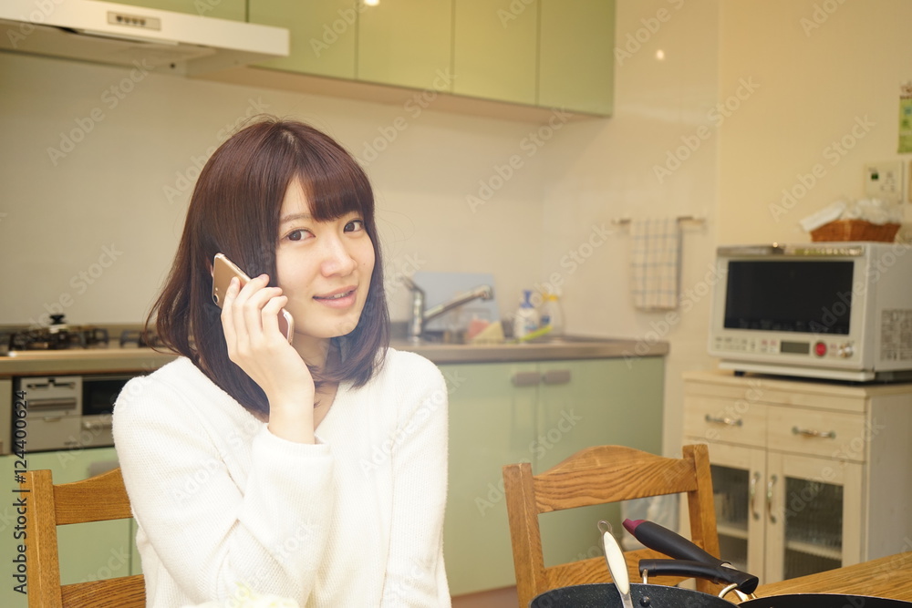 Young woman preparing healthy food in the kitchen while talking on the phone Young woman preparing healthy food in the kitchen while talking on the phone