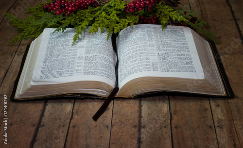 Foto An Old Rustic Bible with Christmas Garland on a wood plank board
