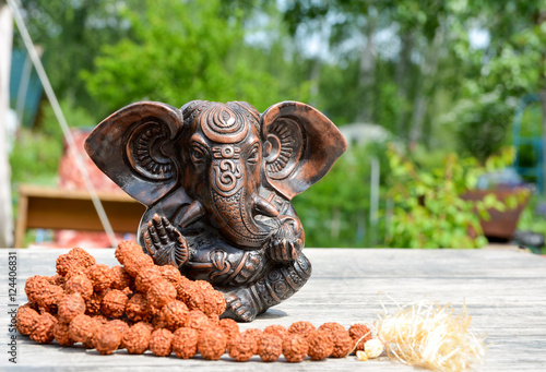 Statuette of Hindu God Ganesha and a rosary from the fruit of the Rudraksha tree  photo