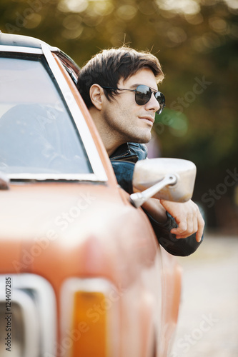 Handsome male model posing in car photo