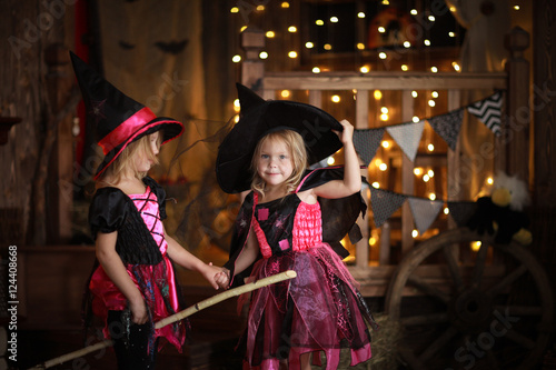 funny children girls in witch costume play for Halloween dark