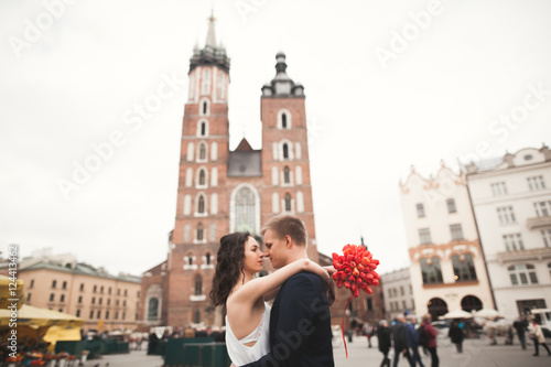 Elegant beautiful wedding couple walking on the main square in Krakow