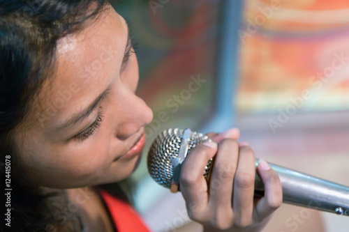 Portrait of Asian woman singing with a microphone