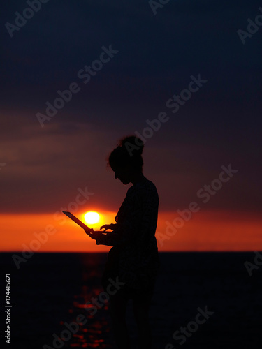 female silhouette with laptop on sunset © Volodymyr