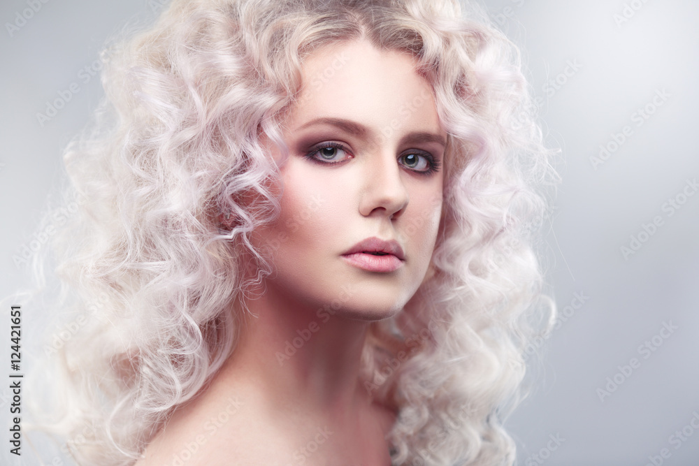 Fashion beauty portrait of a fragile girl gorgeous blonde with a cloud of small curls in pastel colors