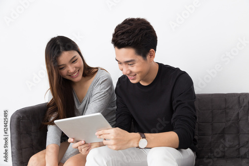 Asian couple playing tablet