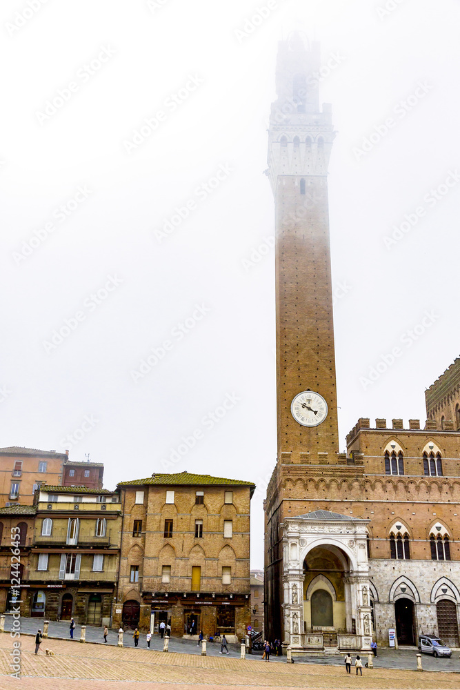 Downtown Siena in Tuscany with Town Hall Tower in fog