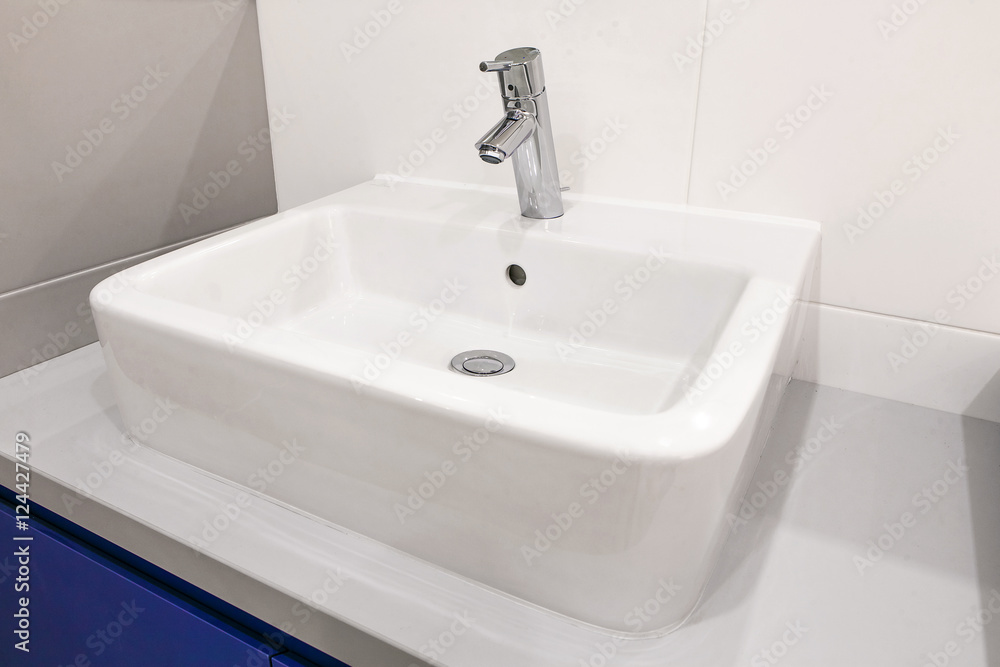 White sink faucet in the bathroom. White sink faucet in the bathroom.